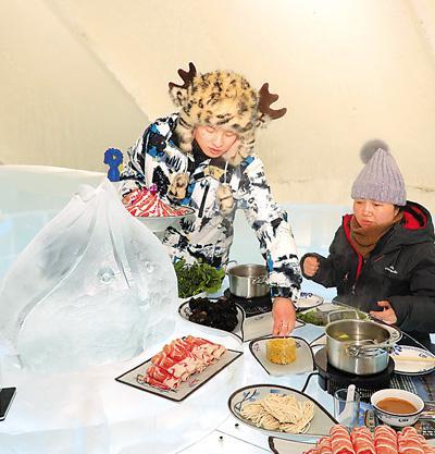 游客在哈爾濱冰雪大世界園區“冰屋”品味“冰火鍋”