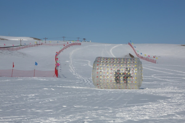 11月26日,昭蘇縣滑雪場開門迎客,游客在游玩娛樂項目